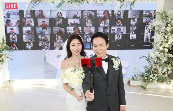 图为4月4日，线上邀请宾客出席“云婚礼”的一对新娘新郎在江南区某婚礼礼堂举行“YouTube直播婚礼”。