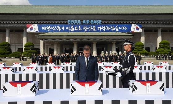 图为2018年10月1日文在寅总统在国军遗骸归还仪式上对曾在6.25韩国战争中战死的64位勇士的遗骸肃穆默哀。【照片来源：青瓦台摄影记者团】