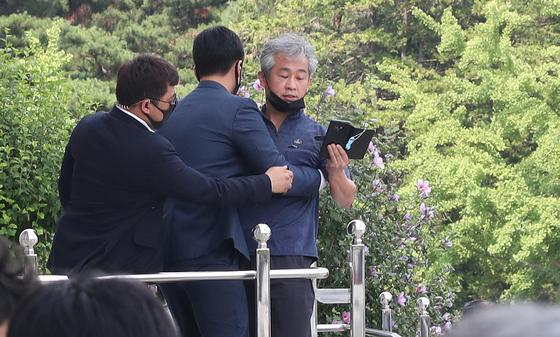 图为16日下午在首尔汝矣岛国会举行第21届国会开院仪式，图为总统警卫正在阻拦向文总统扔出鞋子的市民。【青瓦台摄影记者团】