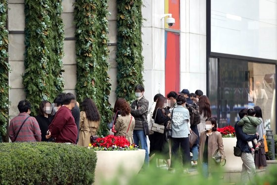 图为去年11月，在首尔小公洞乐天百货商店Avenuel名品馆门前，顾客们正排着队等待香奈儿卖场开门。【照片来源：NEWS1】