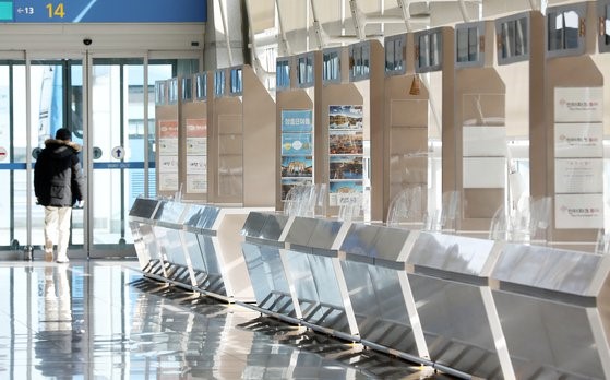 由于新冠肺炎疫情的长期化，旅游行业的裁员也不可避免。图为1月25日韩国仁川国际机场第1航站楼出境大厅的旅行社柜台前空无一人。【照片来源：News1】