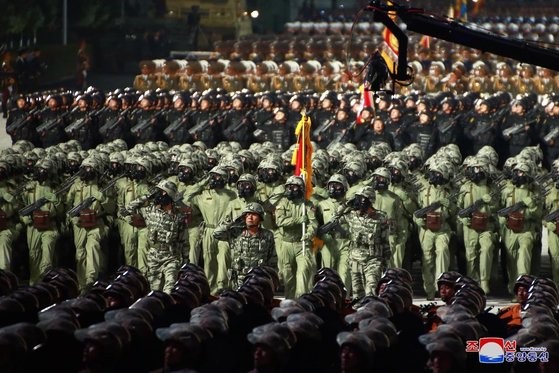 图为去年10月10日深夜举行的劳动党建党75周年阅兵仪式中朝鲜带防毒面具、穿生化防护服的部队方阵正在接受检阅。朝鲜具备发动大规模生化战争的能力。【朝中社】
