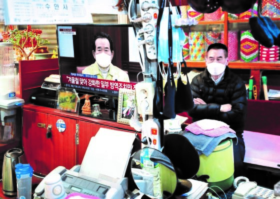 韩国国务总理丁世钧1月31日宣布将目前的防疫等级延长到春节假期结束。图为当日首尔广藏市场某商店中电视里正在播出丁总理公布决定的画面。【照片来源：NEWS1】