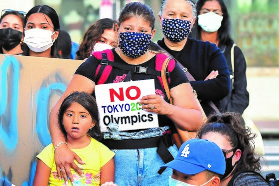 尽管东京奥运会进入倒计时一个月，但日本及全球各地仍有民众在进行反对奥运会举办的示威。图为一位女士在美国洛杉矶的小东京区域参加反对东京奥运会举办的示威。【美联社=韩联社】