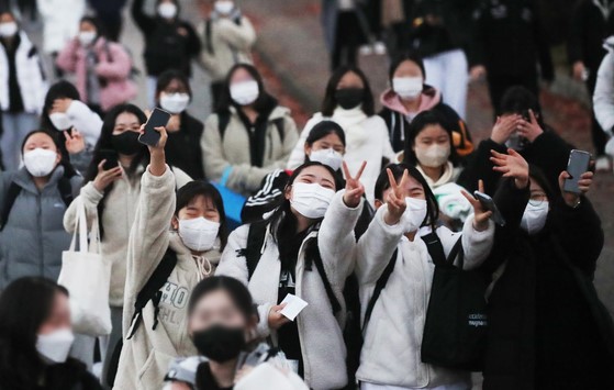图为18日下午，韩国京畿道水原市永福女子高中结束高考的考生们走出考场。【照片来源：韩联社】