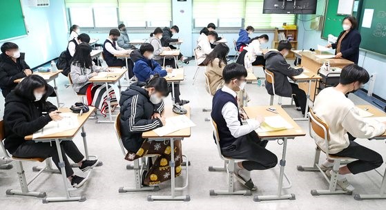 图为2021年11月韩国某高中举行的高考开始前，考生们正在等待考试开始。【照片来源：韩联社】