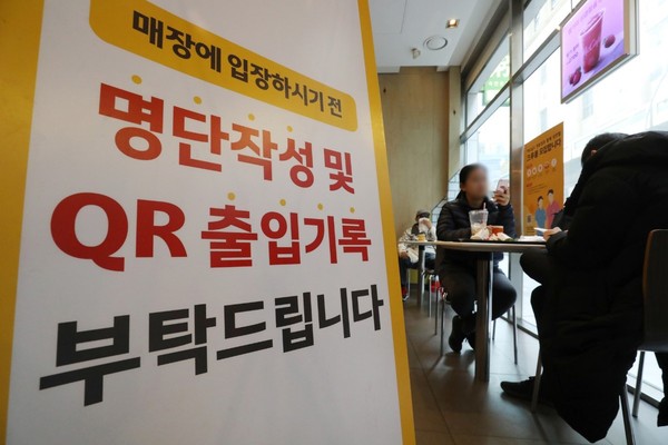 图为6日首尔一家快餐店的门口贴出了建议在入场前扫二维码登记的公告。【照片来源：NEWS1】
