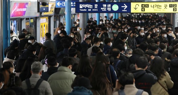 12月15日，韩国新增新冠确诊人数刷新历史新高，图为在首尔九老区地铁1号线新道林站的站台上，戴口罩的市民匆匆走过。【照片来源：NEWS1】