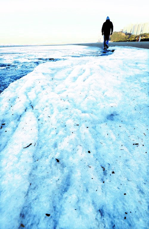 12月26日食今年的最后一个星期天，当天首尔的最低气温降到零下15.5度，创41年来同期最低气温记录，全国各地寒冷达到极致。图为，当天上午在发布暴雪预警的济州市獬豸山丘十字路口，一辆汽车停在十字路口。同一天，釜山沙下区多大浦海水浴场沙滩上的海水已经冻结成厚厚的冰。【照片来源：韩联社、NEWSIS】