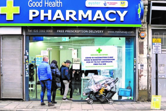 圣诞节当日，伦敦居民在药店前排队注射新冠疫苗。【照片来源：美联社=韩联社】