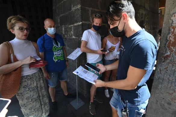 在意大利工作人员在博洛尼亚阿西内利塔入口处查看游客的“绿色通行证”。【图片来源：今日头条】