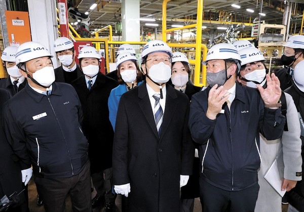 韩共同民主党总统候选人李在明(右三)1月4日访问京畿道光明市起亚汽车工厂，在厂长柳哲熙(音)的带领下参观工厂。【照片来源：国会摄影记者团】