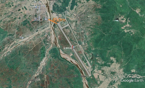 位于咸镜南道长津郡的长津机场跑道接近距离民宅450米的地方。在跑道的北端，有一条柏油马路延伸到地下机库。【图片来源：谷歌地球】