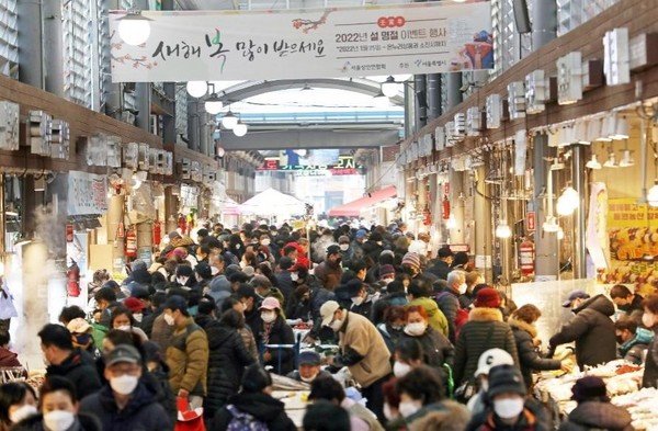 离春节还有一周，图为23日首尔东大门区清凉里综合市场挤满了购物的市民。小商工人振兴公团在10~14日以37家传统市场和附近的37家大型超市为对象，对27种祭祀用品的价格进行了比较调查，结果显示传统市场比大型超市价格低23%左右。【照片来源：NEWSIS】