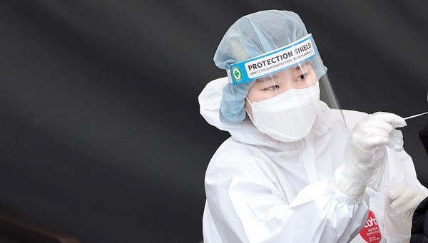 图为3月17日上午，首尔站筛查诊疗站的医疗人员正在进行新型冠状病毒肺炎(COVID)病毒检测。据韩国中央防疫对策本部的数据显示，截至当日0点，韩国新增确诊人数为62.1328万人。【照片来源：韩联社】