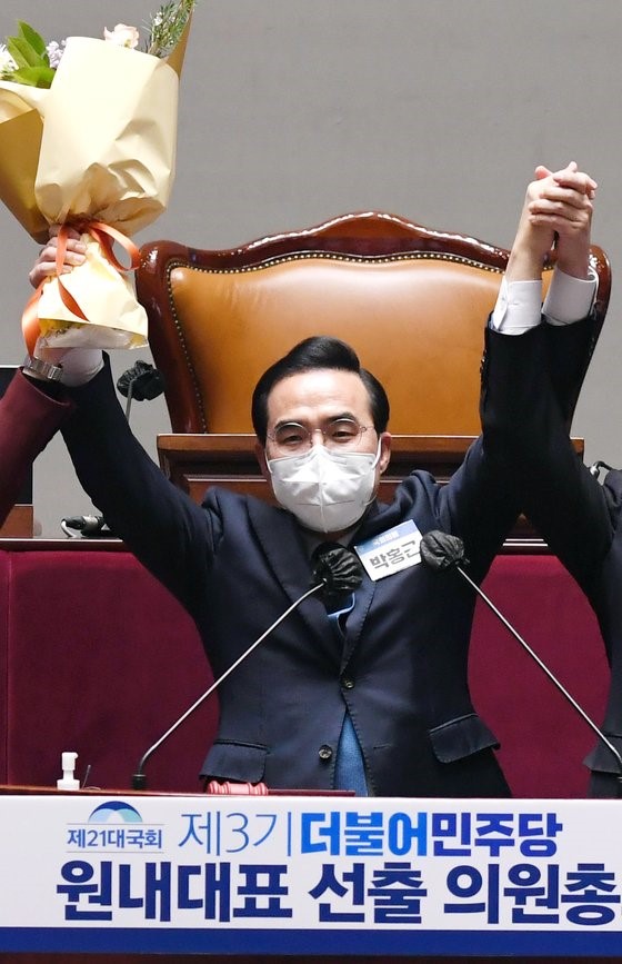 韩国共同民主党新任党首朴洪根3月24日在国会召开的议员总会上当选为院内代表后，正在举起花束。【国会摄影记者团】