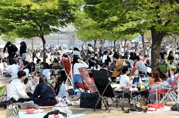 图为17日下午，首尔汝矣岛汉江公园内挤满了游客。【照片来源：韩联社】