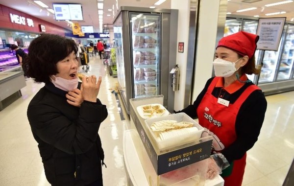 韩25日起解除公共场所内饮食摄取限制，图为当天下午，在大邱寿城区一家大型超市的冷冻食品柜台，一位顾客正在品尝。【照片来源：NEWSIS】
