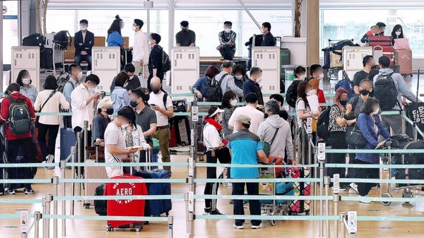 图为16日在仁川国际机场第一航站楼出境大厅，旅客们正在办理登机手续。【照片来源：NEWS1】