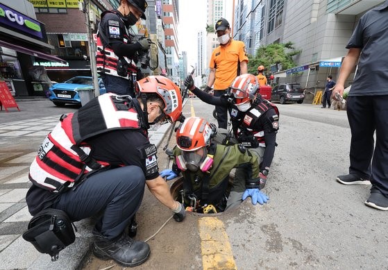 图为8月10日上午，在首尔瑞草区江南站附近，119救援人员正搜寻8日因暴雨掉入窨井口后失踪的瑞草区兄妹。【摄影：禹相助 记者】