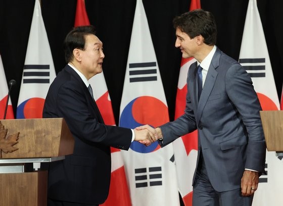 图为尹锡悦总统(左)和加拿大总理特鲁多23日(当地时间)在加拿大首都渥太华举行共同记者会后正在握手。【韩联社】