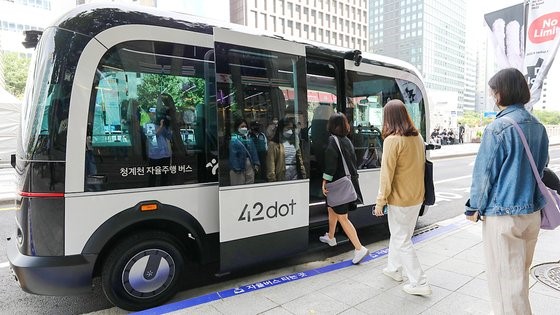 图为26日，市民们正搭乘在首尔清溪广场开始试运行的自动驾驶电动班车。该班车将从今年10月开始沿着清溪川实际运行。首先运行的路线是从清溪广场出发到达世运商业街后再返回。【照片来源：NEWS1】