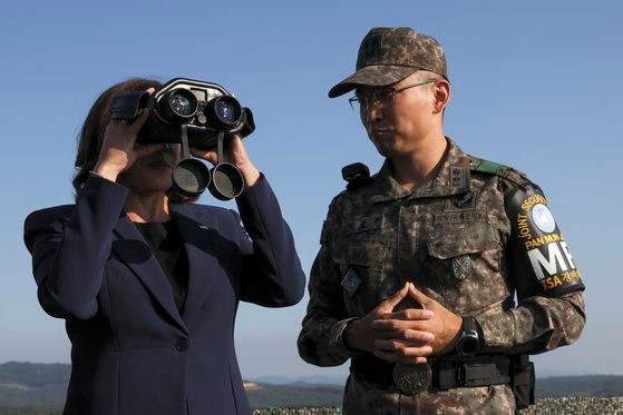 图为美国副总统哈里斯(左)29日访问京畿道坡州市板门店附近的非军事区(DMZ)，在共同警备区(JAS)要员的引导下，正用望远镜观察朝鲜方面。【照片来源：美联社=韩联社】