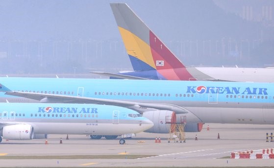 图为10月2日上午，大韩航空和韩亚航空公司的客机停在仁川国际机场内。【照片来源：韩联社】