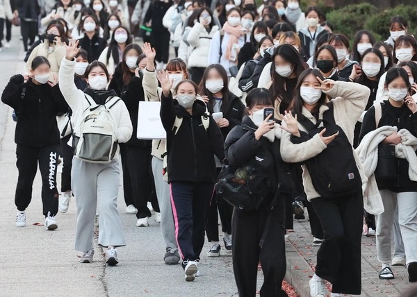 图为2023年韩国高考开考的17日下午，在京畿道水原市八达区荣福女子高中结束考试的考生们满脸笑容地走出考场。【照片来源：韩联社】