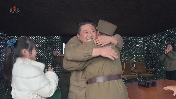 图为朝鲜国务委员长金正恩拥抱负责发射试验的参谋并给予鼓励。年幼的女儿和夫人李雪珠女士在两边拍手欢呼。【照片来源：朝鲜中央电视台=韩联社】