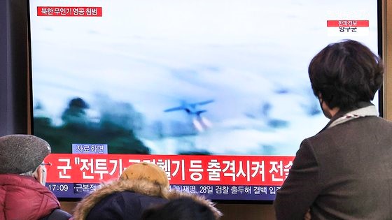 图为26日，首尔市民在首尔站候车室观看有关朝鲜无人机侵犯韩国领空的新闻。【照片来源：韩联社】