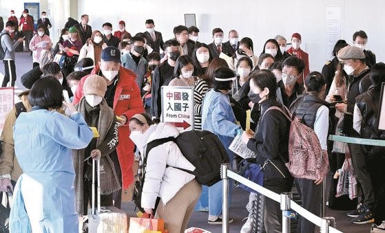 图为2日，在仁川国际机场第一航站楼入境处，机场工作人员正在对中国入境人员进行分类。【照片来源：韩联社】