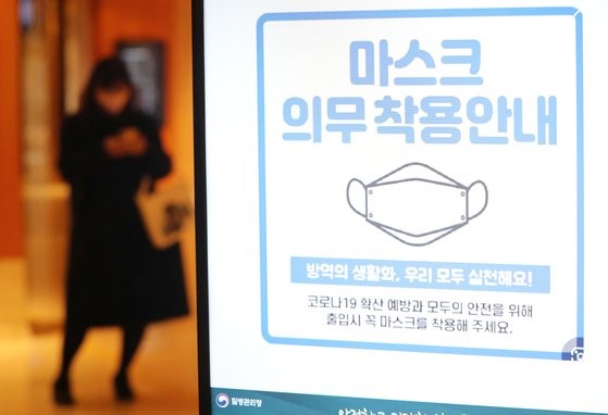 图为17日下午，首尔市内某酒店贴出的室内佩戴口罩强制规定提醒。【照片来源：NEWS1】