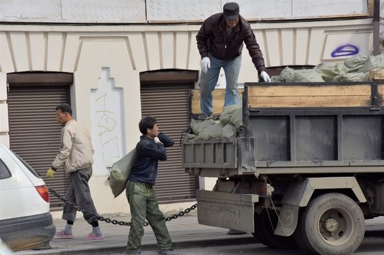 图为在俄罗斯符拉迪沃斯托克市内进行住宅改造作业的朝鲜劳工。【照片来源：东亚大学教授姜东皖(音)】
