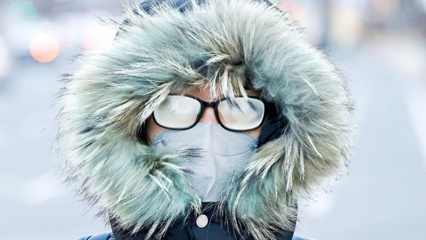 25日，春节长假结束回归日常后，韩国早间气温降到了今年入冬以来的最低值。据韩国气象厅透露，当天上午首尔最低气温为零下17.3℃，体感温度降至零下25℃左右。图为当天在光化门广场，一位戴着外套帽子上班的市民。【照片来源：韩联社】