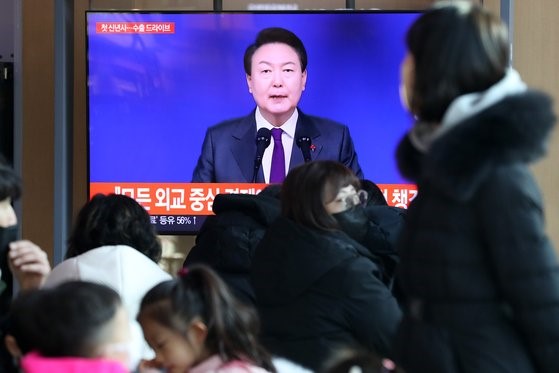 图为今年1月1日，市民们在首尔站观看韩国总统尹锡悦发表2023年癸卯年新年致辞。【照片来源：NEWS1】