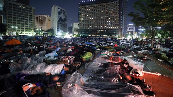 图为17日凌晨，在首尔中区市厅前的首尔广场上，民主劳总建设工会成员正在露宿。【照片来源：NEWSIS】