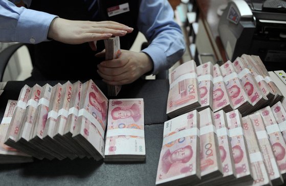 中国一家银行的职员正在数人民币。【照片来源：路透社=韩联社】