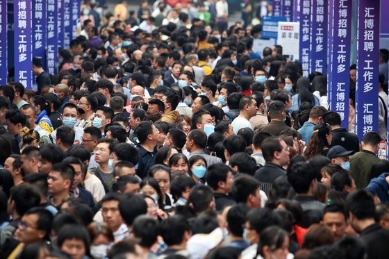 图为今年4月重庆就业博览会上求职者蜂拥而至的情景。【照片来源：AFP=韩联社】