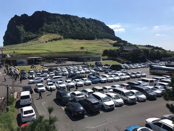 每逢周末和公休日，济州岛城山日出峰停车场就停满了租车自驾游的车辆。【摄影：崔忠一 记者】