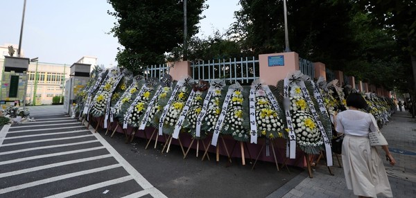 20日上午，首尔瑞草区一所小学前摆放着追悼花圈。据教育界透露，该校班主任A某在学校内自杀死亡。【照片来源：韩联社】