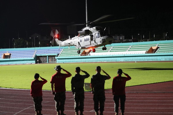 图为当天在庆北醴泉体育场乘载者遇难队员的海军陆战队直升机在战友们的敬礼中起飞。【照片来源：韩联社】