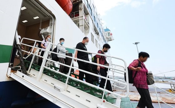 因新冠疫情中断的韩中国际客轮12日恢复运营。图为从中国威海港乘坐客轮进入平泽港的中国旅客。【照片来源：韩联社】