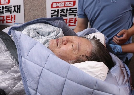 图为18日上午，绝食第19天的共同民主党代表李在明在国会党代表室被119急救队送往医院。【照片来源：NEWS1】