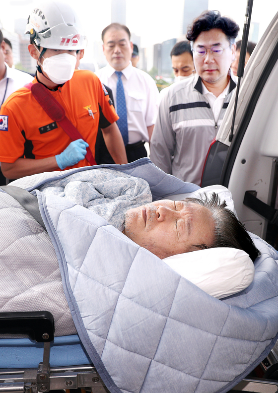 图为18日上午已绝食19天的共同民主党代表李在明在国会党代表室被119急救队送往医院。【照片来源：NEWS1】