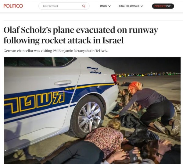 当地时间17日晚，德国总理朔尔茨在以色列本古里安机场登机前突遇火箭弹袭击，人员紧急躲避。图片来源：美国政治新闻网报道截图