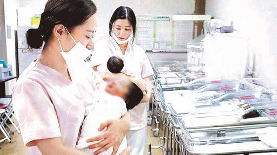 图为一家妇产科新生儿室正在照顾新生儿的护士们(图文无关)。【摄影：金成泰】