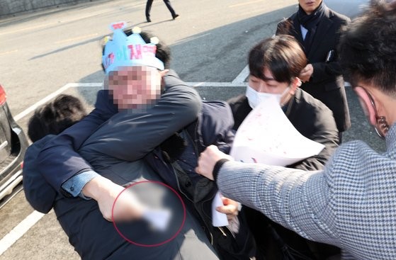 图为2日上午在釜山江西区大项瞭望台用凶器袭击共同民主党代表李在明的嫌疑人被警方当场逮捕，被捕时手中还拿着凶器。【照片来源：NEWSIS】