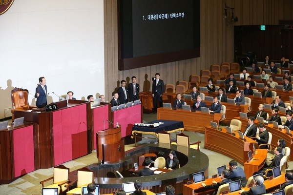 图为2016年12月9日国会议长丁世均在国会全体会议上宣布通过朴槿惠总统弹劾案。