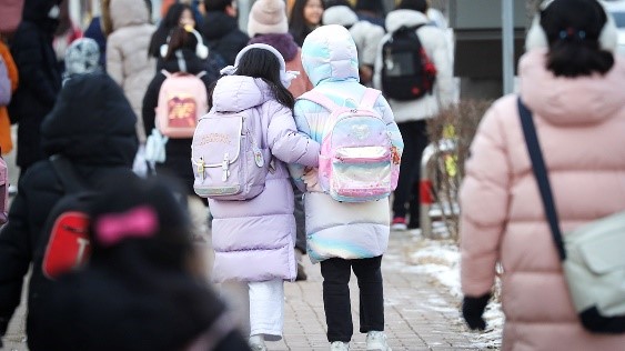 图为去年12月，在京畿华城市的一所小学前，孩子们正在进入校园。【照片来源：NEWS1】